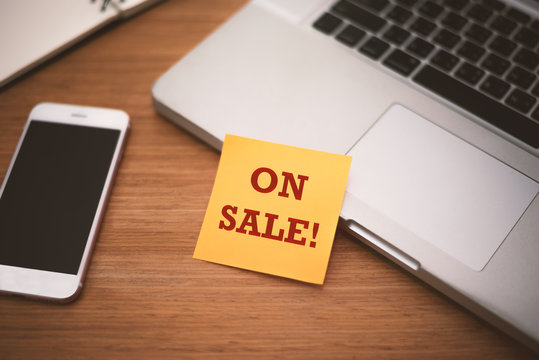 "Order Now" text on post it paper near laptop and smart phone on wood table, Online shopping and Technology marketing concept. Split and cross processing tone pinterest and instragram like process.