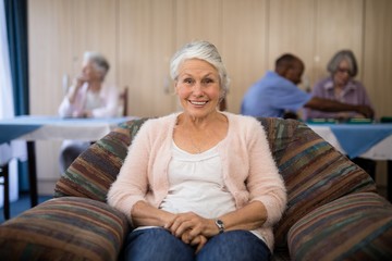 Portrait of happy senior woman sitting on couch