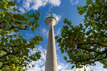 Low-angle view of the Rhine Tower in Dusseldorf against a cloudy blue sky © gerduess