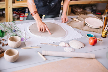 Fototapeta na wymiar artist woman hands working red clay to create handcraft art