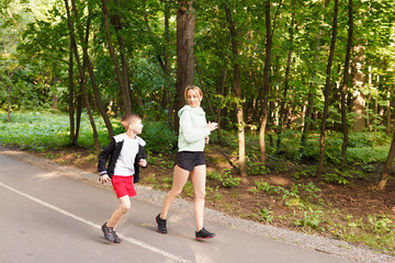 Obraz premium Young family jogging in the open air Happy mom with 9 years old child running at summer park