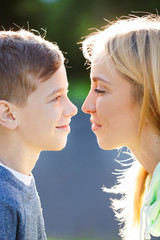 The son with his mom outdoors. Mother and her child having fun together. Little kid express the love to his young mommy.