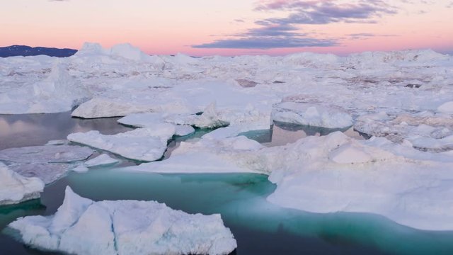 Iceberg from glacier in arctic nature landscape on Greenland. Aerial video drone footage of icebergs in Ilulissat icefjord. Affected by climate change and global warming.