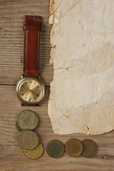 Old paper and coins on a wooden table