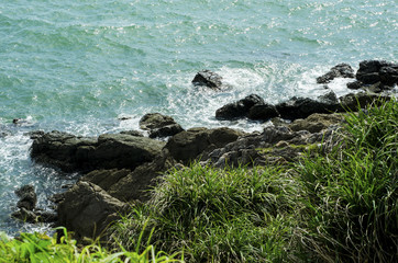 Green grass, rocks and a blue sea