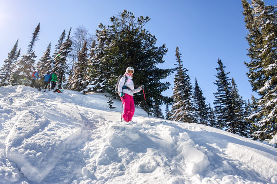 Woman skier rides through powder snow to the mountains. Winter sports freeride