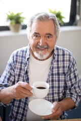Portrait of smiling senior man holding coffee cup