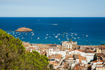 Fototapeta premium Top view of the town of Tossa de mar, city on the Costa Brava. Buildings and hotels by the beach. Amazing city in Girona, sea and moored boats in Catalonia. City and see.