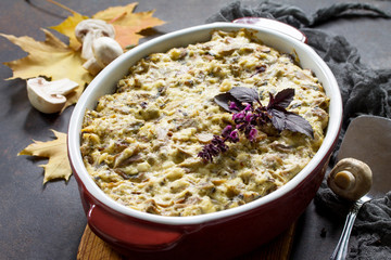 Baked potatoes with mushrooms, sour cream and cheese on a brown stone or slate background.