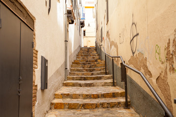 Stairs between houses near the narrow streets of Lloret de Mar. Downtown of Lloret, Spain.