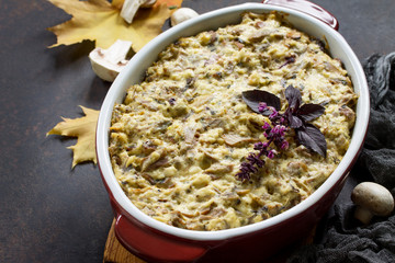 Baked potatoes with mushrooms, sour cream and cheese on a brown stone or slate background. Copy space.