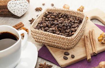 black coffee and grains of coffee in a basket, kitchen table.