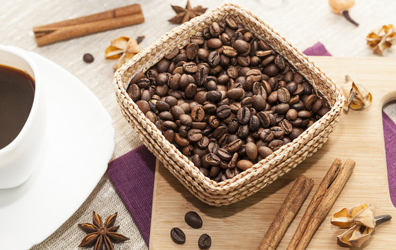 black coffee and grains of coffee in a basket, kitchen table.