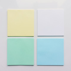 Four square sheet of paper on a white background. Top view. Close-up