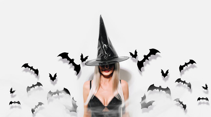 blonde girl in a halloween witch costume on a white background