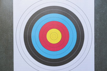 face view of an archery target over a black background, sport and business success concept