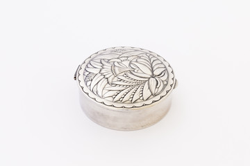 Obraz premium A beautiful vintage silver jewellery box with flower ornament and closed lid on white background.