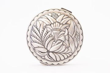 A beautiful vintage silver jewellery box with flower ornament and closed lid on white background.