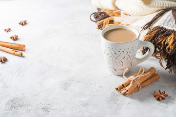Obraz na płótnie Canvas Cup of creamy latte with spices and cozy plaids