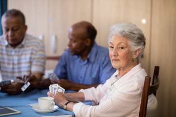 Obraz premium Portrait of senior woman sitting with friends while playing