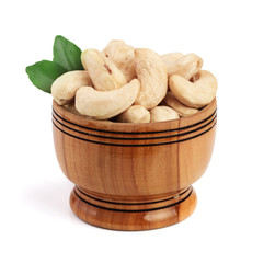 Cashew in a wooden bowl with leaf isolated on white background