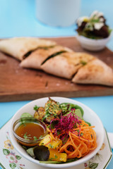 Ensalada saludable de pollo y focaccia vegana sobre madera. 