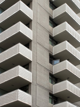 modern white concrete apartment block with geometric angular balconies vertical view