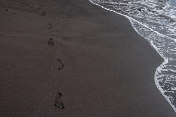 foot prints on black sand