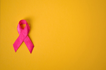 pink ribbon breast cancer on a yellow background. top view  top. Place for text.