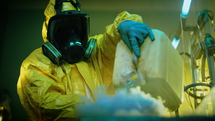 In the Underground Drug Laboratory Clandestine Chemist Wearing Protective Mask and Coverall Mixes...