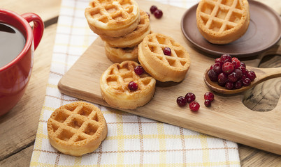 Viennese round wafers with cranberry berries and a cup of black coffee