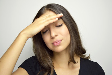 Young woman having and headache or forget something important isolated on gray background. Copy space.