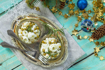 Homemade holiday snack Christmas table. Salad with marinated cucumber, potatoes, crab sticks, green peas and egg. Top view. © elena_hramowa