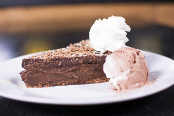 Delicious chocolate cake on plate on table on a dark background. Beautiful restaurant dessert.