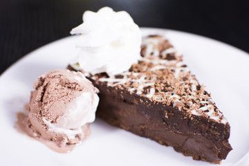 Delicious chocolate cake on plate on table on a dark background. Beautiful restaurant dessert.