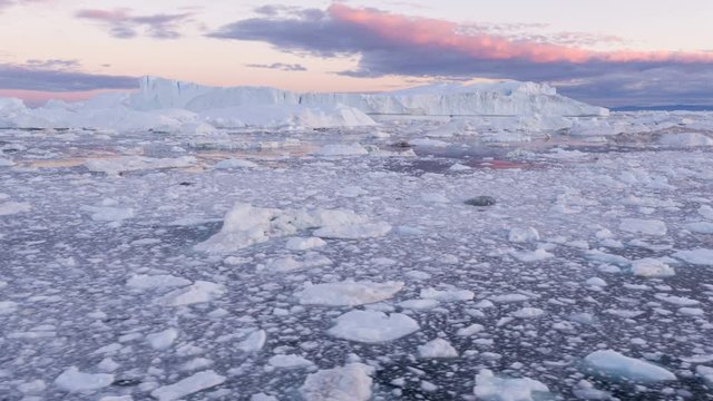 Climate Change and Global Warming - Icebergs from melting glacier in icefjord in Ilulissat, Greenland. Aerial video of arctic nature ice landscape. Unesco World Heritage Site.