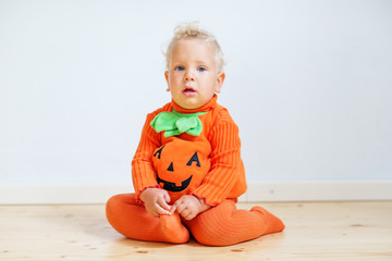 Small boy in pumpkin costume posing at studio