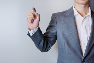 Digital composite of Midsection of businessman hand pushing screen on light background. Selective focus on the finger.