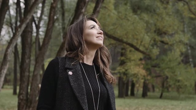 Beautiful girl walks smiling in autumn in the park