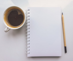 A notebook, a pencil, a Cup of coffee on a white background. Top view 