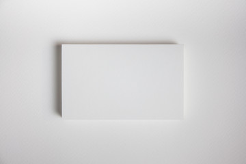 Mockup of business cards fan stack at white textured paper background.