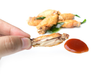 hand holding fried chicken wings and ketchup isolated on white background