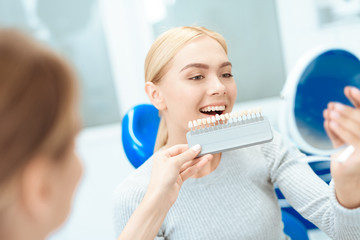 A woman came to see a dentist for teeth whitening. The dentist determines the color of her teeth