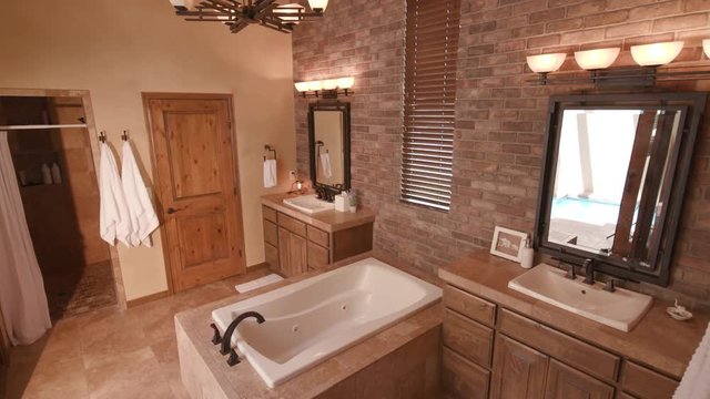 Master Bath Double Sink Lower. a lowering shot of a large master bathroom with two sinks and a tub spa in the middle
