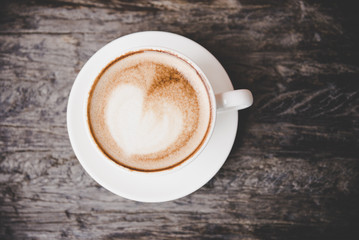 The shape heart on the cup of coffee morning on old wooden table. Lifestyle Concept