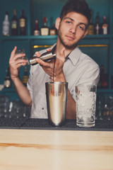 Bartender pouring syrup into shaker