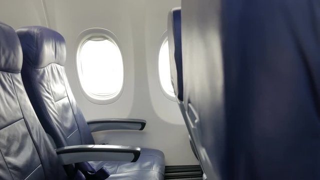 Interior of commercial airplane cabin with blue passenger seats.