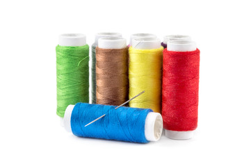 Colored threads with sewing needle on a white.