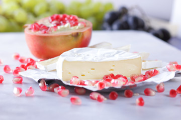 Camembert cheese, sliced cheese, lots of cheese with pomegranate seeds on white background