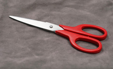 Single scissors isolated on the grey background